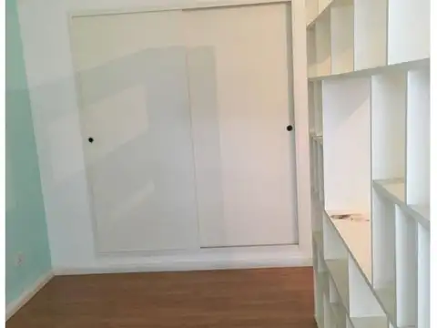 Monoambiente en forma de L divisible frente balcón