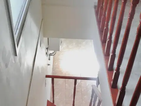 Dúplex de tres ambientes con estacionamiento para auto y jardín.