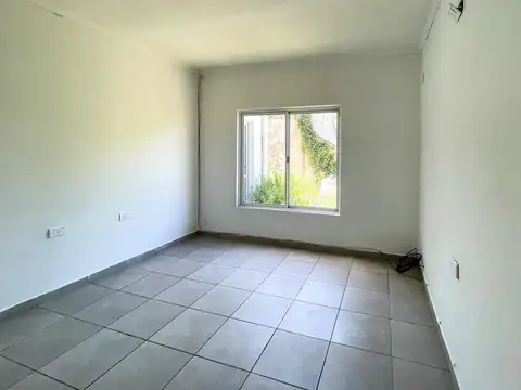 Casa de dos dormitorios, fondo con verde.Impecable