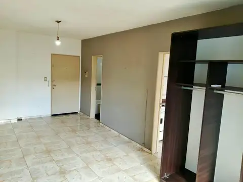 Monoambiente con balcón y cocina separada, luminoso